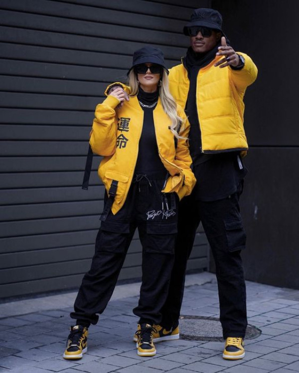 Staying cozy and comfortable, their couple's matching outfit includes warm puffers in mellow yellow for a relaxed look
