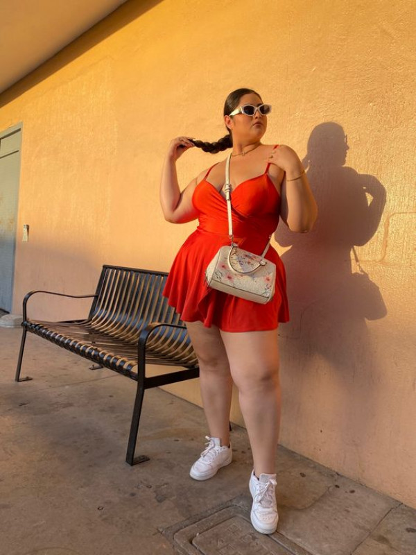 Curvy and cute, she's absolutely rocking that red dress with casual coolness