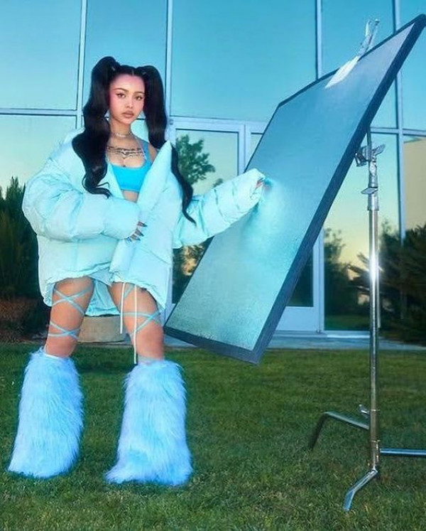 How Her Sky-High Blue Fluff Boots Accentuate Her Legs Against a Modern Backdrop?