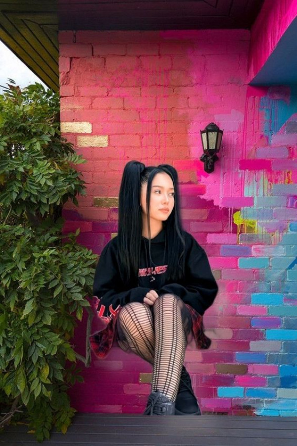 Her Legs and Fishnets Pair Perfectly with the Vibrant Graffiti Wall: Seated casually in front of a vibrant pink and blue graffiti wall