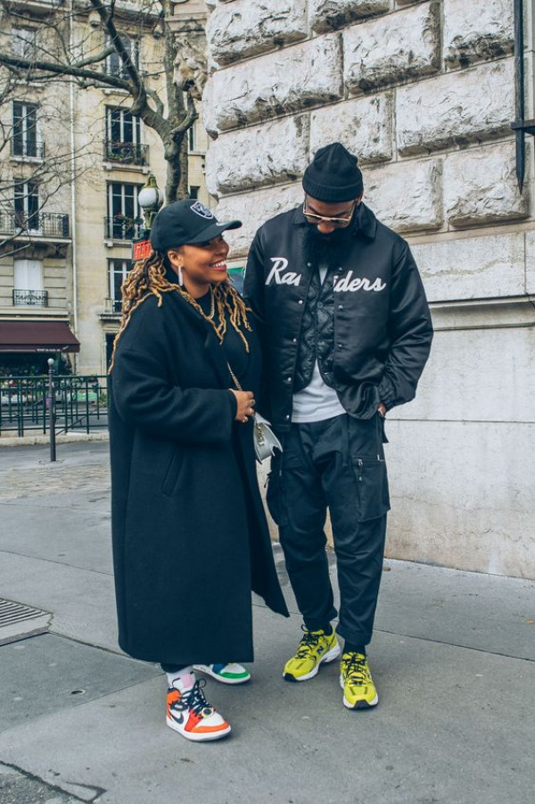 Known as sneakerhead sweethearts, they're sporting a couple's matching outfit featuring cozy layers and vibrant kicks