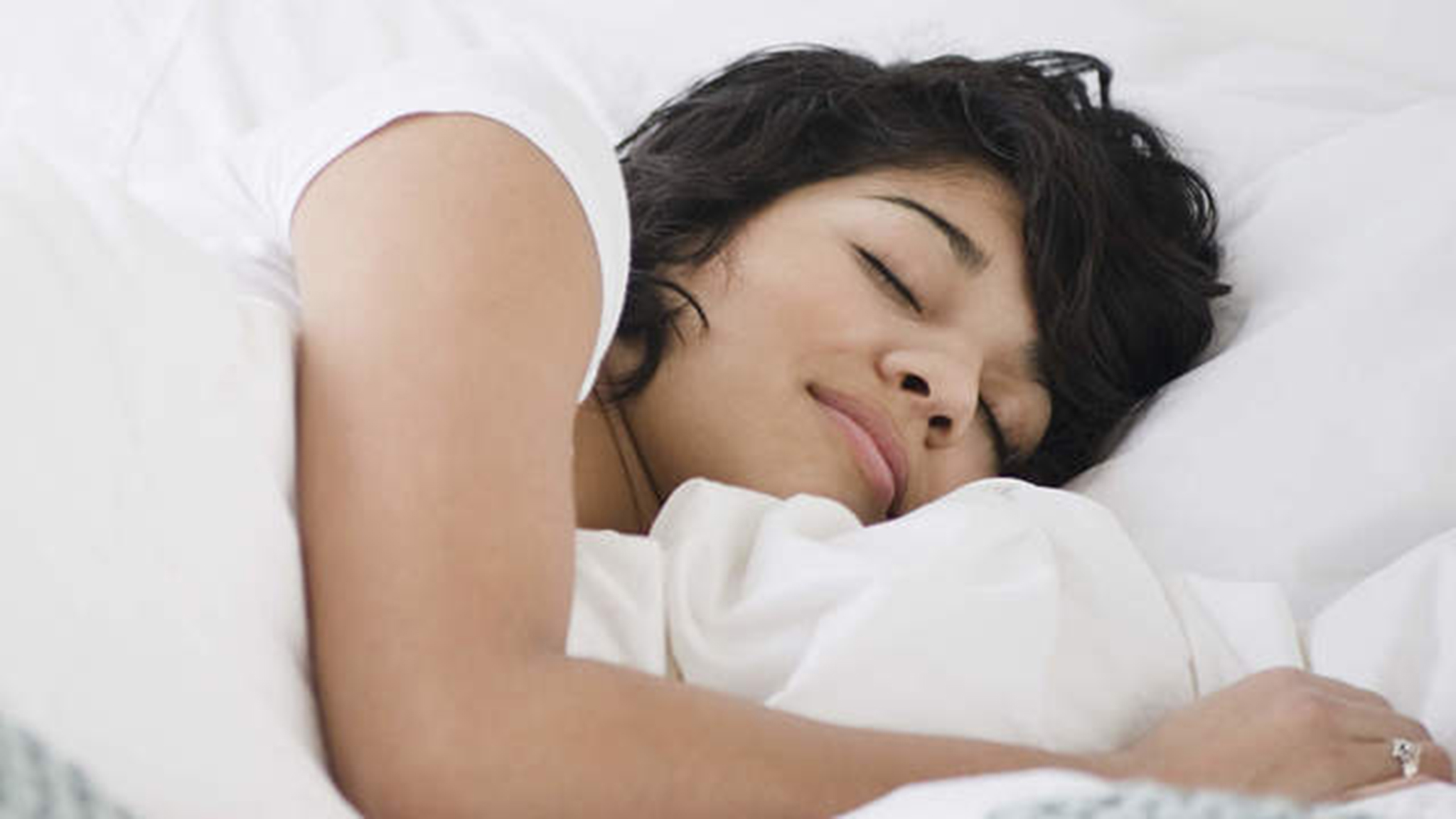 Hispanic woman sleeping in bed